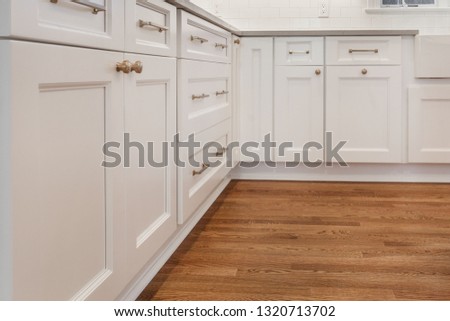 White kitchen built with shaker style cabinets. Shows cabinet details and brushed gold hardware knobs and pulls Royalty-Free Stock Photo #1320713702