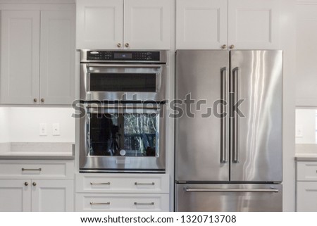 White kitchen built with shaker style cabinets. Shows cabinet details and brushed nickel hardware knobs and pulls Royalty-Free Stock Photo #1320713708