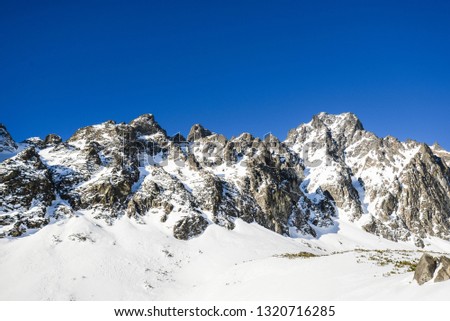 Nice scenery with big rocky mountains in Small Cold valley on hike Hrebienok-Zamkovskeho cottage to Teryho cottage in winter on beautiful sunny day with blue sky and no clouds. High Tatras, Slovakia.