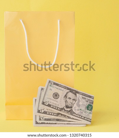 Shopping bags and dollars on a yellow background.