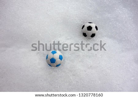 Two children's football balls on sleet  background.