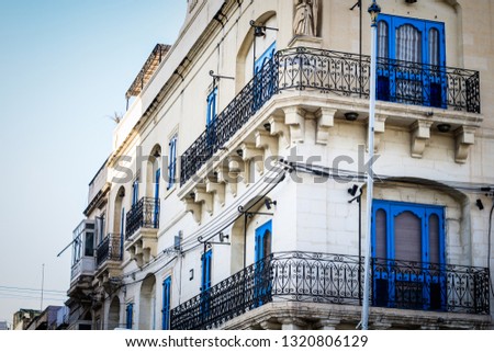 
The picture shows an interesting blue building with many terraces. This building is located in Malta in a city called Valletta