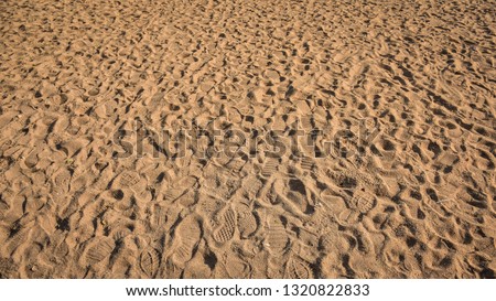 Many footprints on the sand beach texture background.