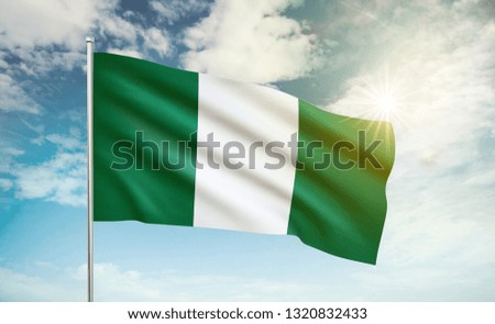 Nigeria flag 2 waving in the wind against a blue sky and clouds