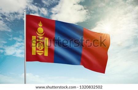 Mongolia flag waving in the wind against a blue sky and clouds