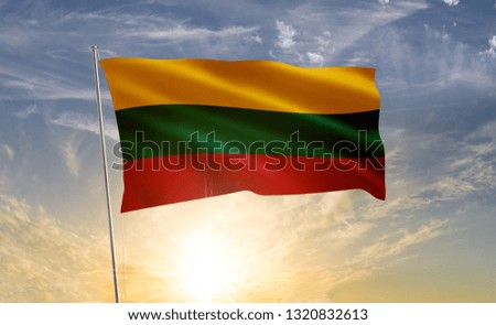 Lithuania flag waving in the wind against a blue sky and clouds