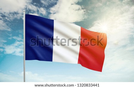 France flag 2 waving in the wind against a blue sky and clouds