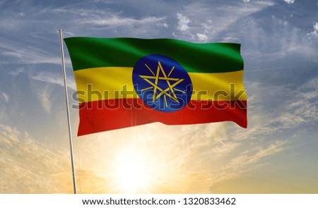 Ethiopia flag waving in the wind against a blue sky and clouds