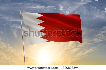 Bahrain flag waving in the wind against a blue sky and clouds