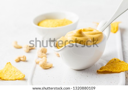 Vegan Cashew Cheese Sauce in white sauceboat, white background. Healthy plant based food concept. Royalty-Free Stock Photo #1320880109