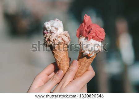 Holding traditional italian ice cream called Gelato in the waffle cone. Venice Murano Island in background