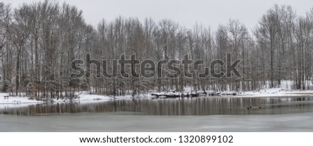 A panoramic view of Holiday Lake with ice and fresh snow in Manalapan New Jersey.