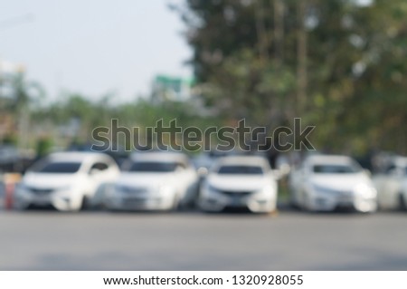 Blurred picture of cars parking in open area, blurred cars parking in open area of a university with surrounding trees