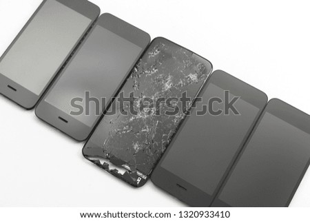 New screens lie near the broken on white background. Phone repair concept