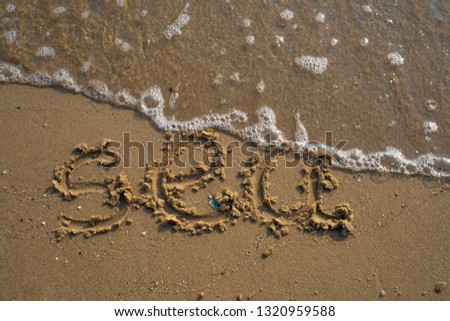 Vacation on the sand beach concept. Sea words written into the sand on the beach at Rayong, Thailand.
