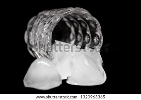 Glass with the ice-bricks on the isolated black background - Image