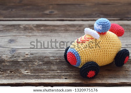 Colored crochet racing car. Toy for babies and toddlers to learn mechanical skills and colors. Handmade crafts. DIY concept.