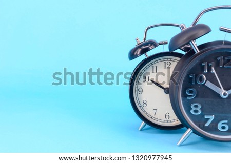 Alarm clock on blue background. Selective focus.