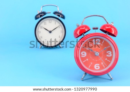 Alarm clock on blue background. Selective focus.