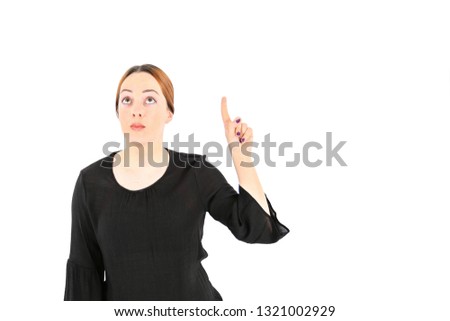 Pretty young woman pointing her finger up against a white background