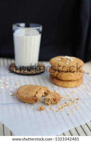 Vegan oat cookies with the glass of oat milk on the dark background Royalty-Free Stock Photo #1321042481