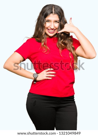 Young beautiful woman wearing casual t-shirt smiling doing phone gesture with hand and fingers like talking on the telephone. Communicating concepts.