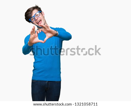 Young handsome man wearing blue glasses over isolated background smiling in love showing heart symbol and shape with hands. Romantic concept.