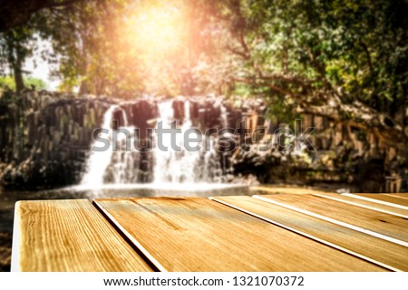Wooden table of free space for your decoration and waterfall background 