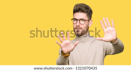Young handsome business man wearing glasses Smiling doing frame using hands palms and fingers, camera perspective