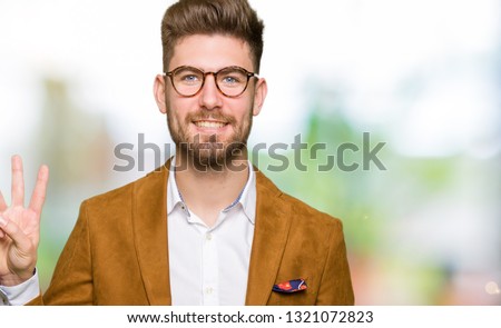 Young handsome business man wearing glasses showing and pointing up with fingers number three while smiling confident and happy.