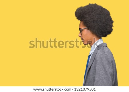Young african american business man with afro hair wearing glasses looking to side, relax profile pose with natural face with confident smile.
