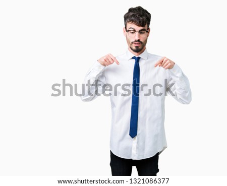 Young handsome business man wearing glasses over isolated background Pointing down with fingers showing advertisement, surprised face and open mouth