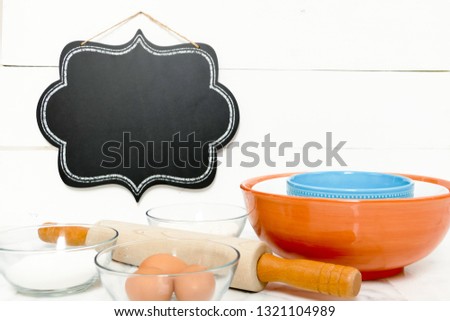 Baking supplies on marble table top with blank chalkboard sign