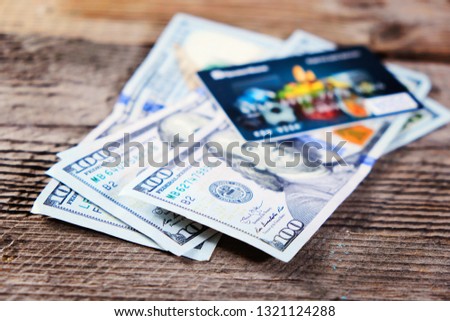 Photo of the bank credit cards and moneys on the wood table, selective focus.