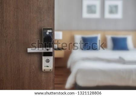 Hotel room opened with digital door access control, Condominium or apartment doorway with open door in front of blur bedroom background
