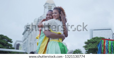 Couple dancing in the carnival of Brazil with the typical scenario of Recife. Frevo dancing.