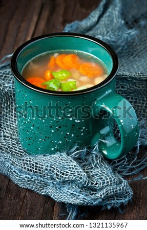 Vegetable soup with carrot, cauliflower, potato and beans  over rustic wooden background 