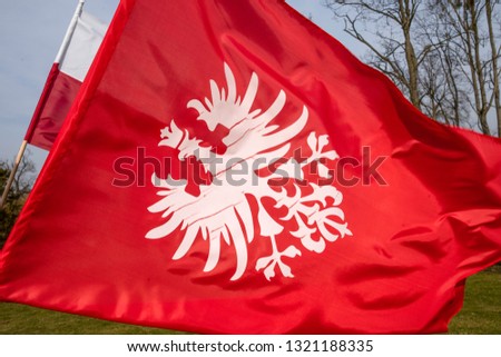 White eagle on red background - flag and emblem of the Greater Poland uprising, polish national colours. Royalty-Free Stock Photo #1321188335
