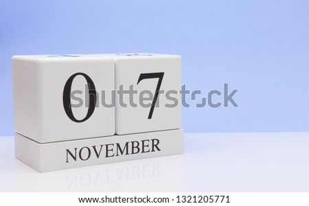 November 07st. Day 7 of month, daily calendar on white table with reflection, with light blue background. Autumn time, empty space for text
