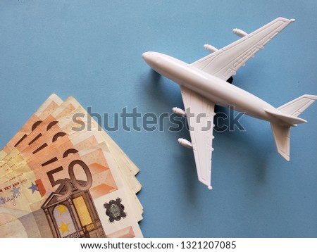 european banknotes, white plastic airplane and blue background