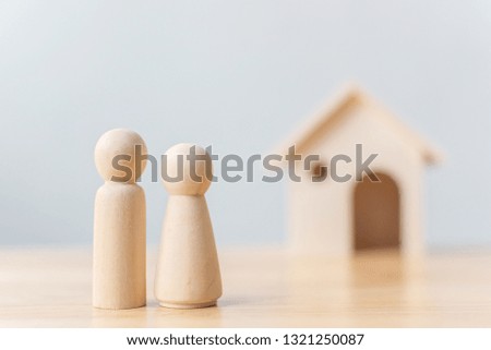 Wood doll couple lover with house. Family home, Insurance and property investment real estate concept