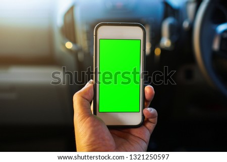 Man driver using smart phone in car, green screen.