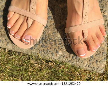 Closeup photo of woman feet in T Strap sandal