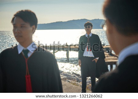 3  bachelor brothers celebrate their graduation  photo set on the beach blue sky to start their road to success with their goals in life, selective-focus