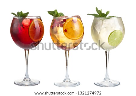 Alcoholic and non-alcoholic refreshing cocktails with mint, fruits and berries on a white background. Three cocktails in glass glasses on a long leg. Isolated.