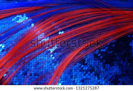 Red strand of hair on a blue shiny background. Fancy Hairstyle