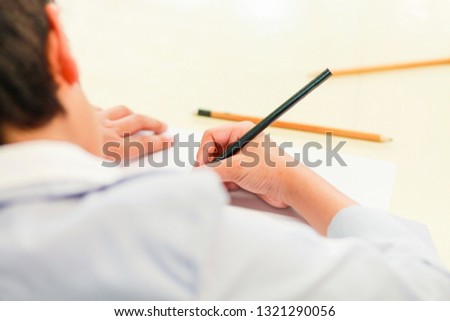 The view of a boy who is using a pencil to draw carefully