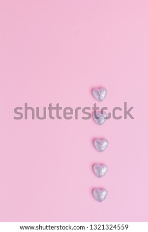 Top view of five silver hearts bottom right on pink background with copy space. Concept of wedding, Valentine's day, date, celebrate. Template for blog, postcards, flyers