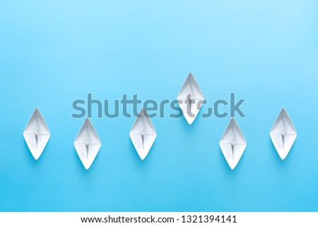 White paper ships on blue background. Business competition concept.