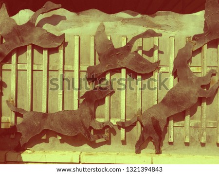 metal fence houses with art figures of hunting dogs and swans, black and gray
